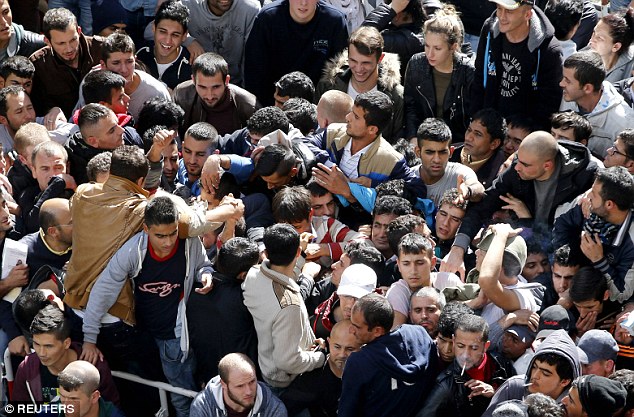 Migrants and refugees queue at the compound outside the Berlin Office of Health and Social Affairs as they wait for their registration. But there are warnings that millions more newcomers should be expected in the current migrant crisis